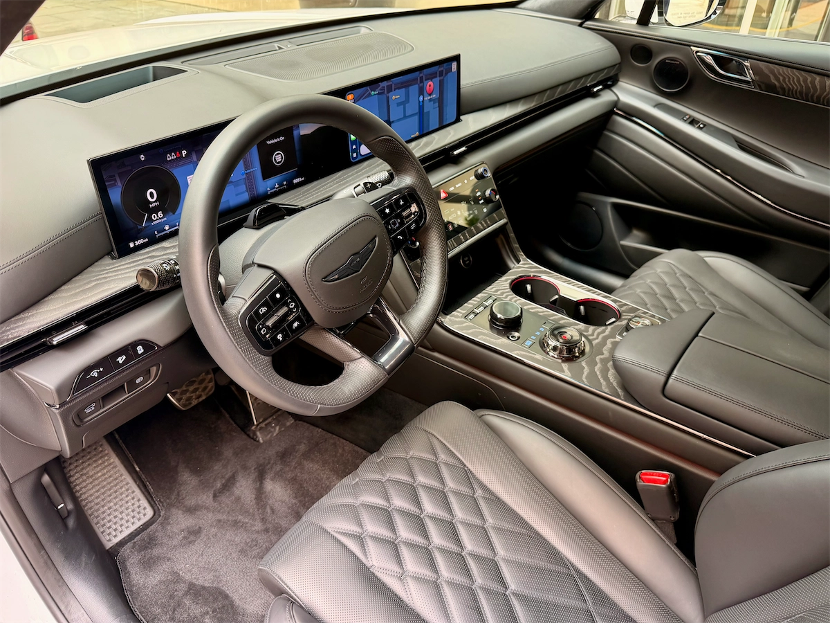 Interior cockpit of a Genesis GV80 Coupe showing the curved display and dashboard