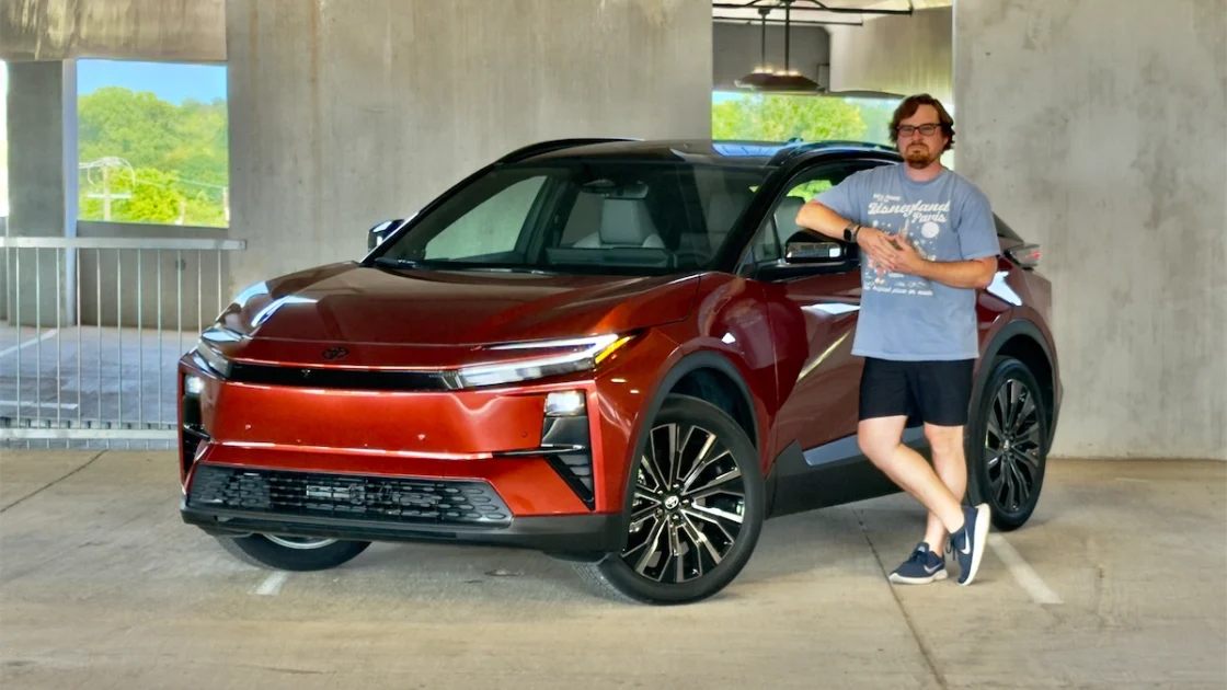 The 2026 Toyota C-HR XSE in Tandoori paint, front three-quarter view with Cory standing beside it after a wash