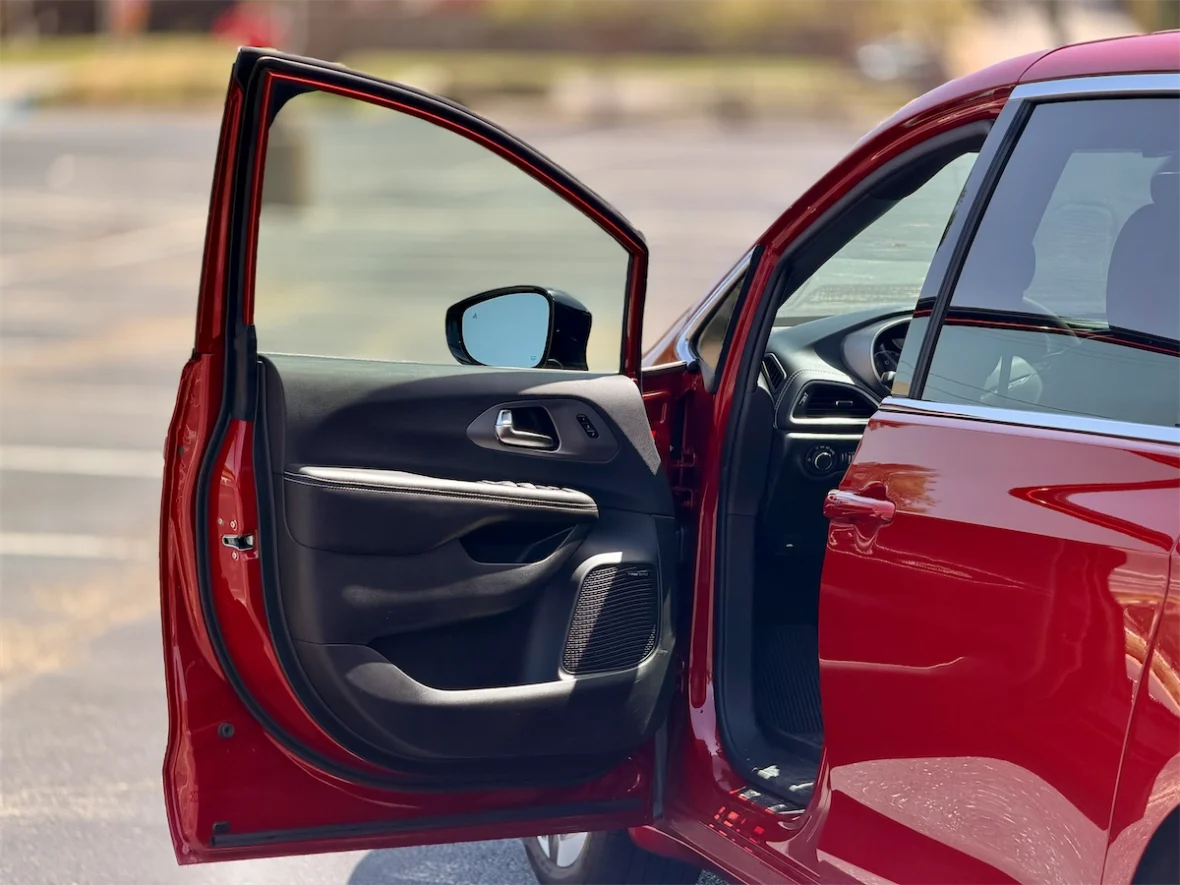 Driver's door open on a red 2027 Chrysler Pacifica
