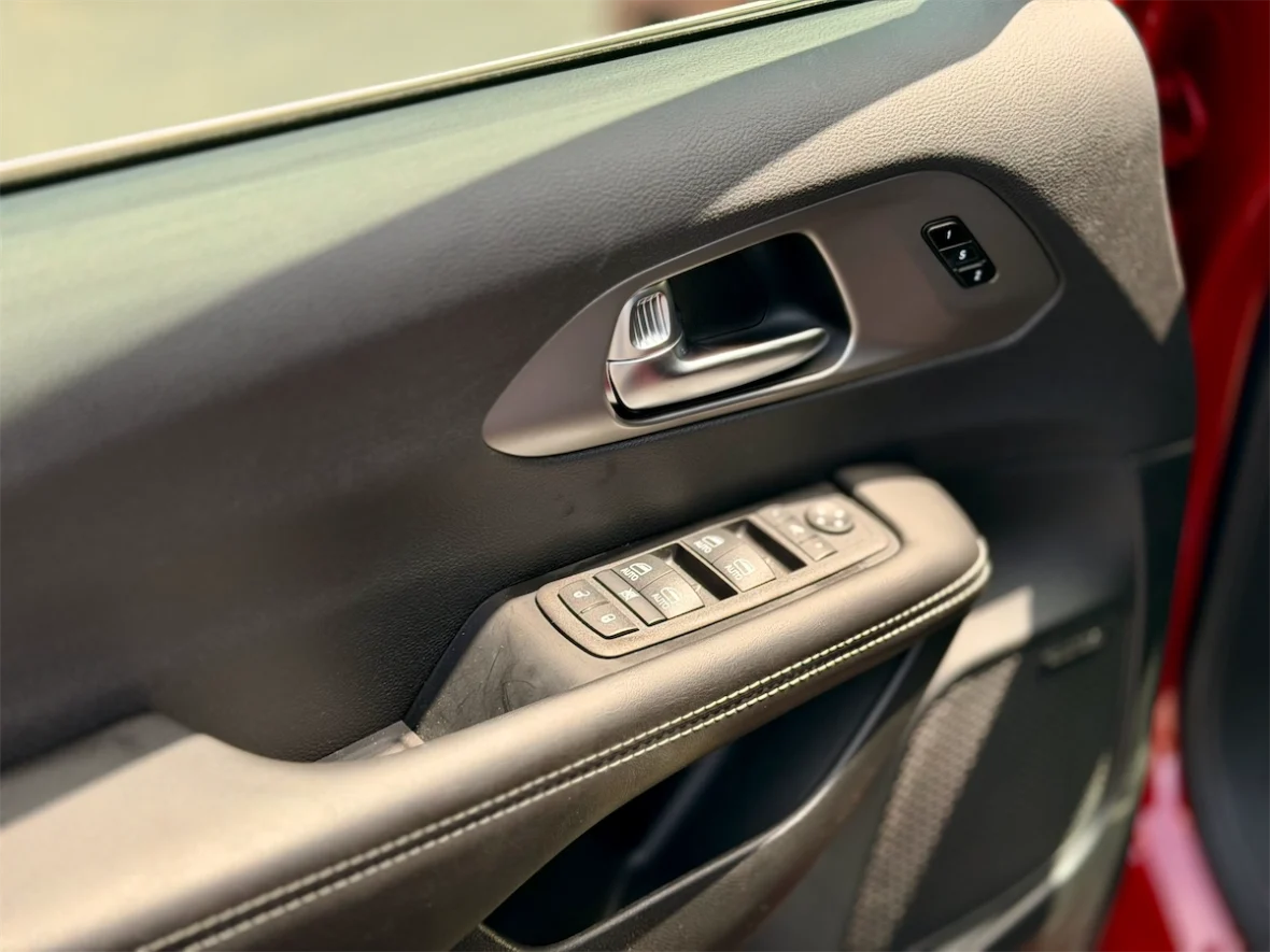 Driver door panel with window and mirror controls in a 2027 Chrysler Pacifica