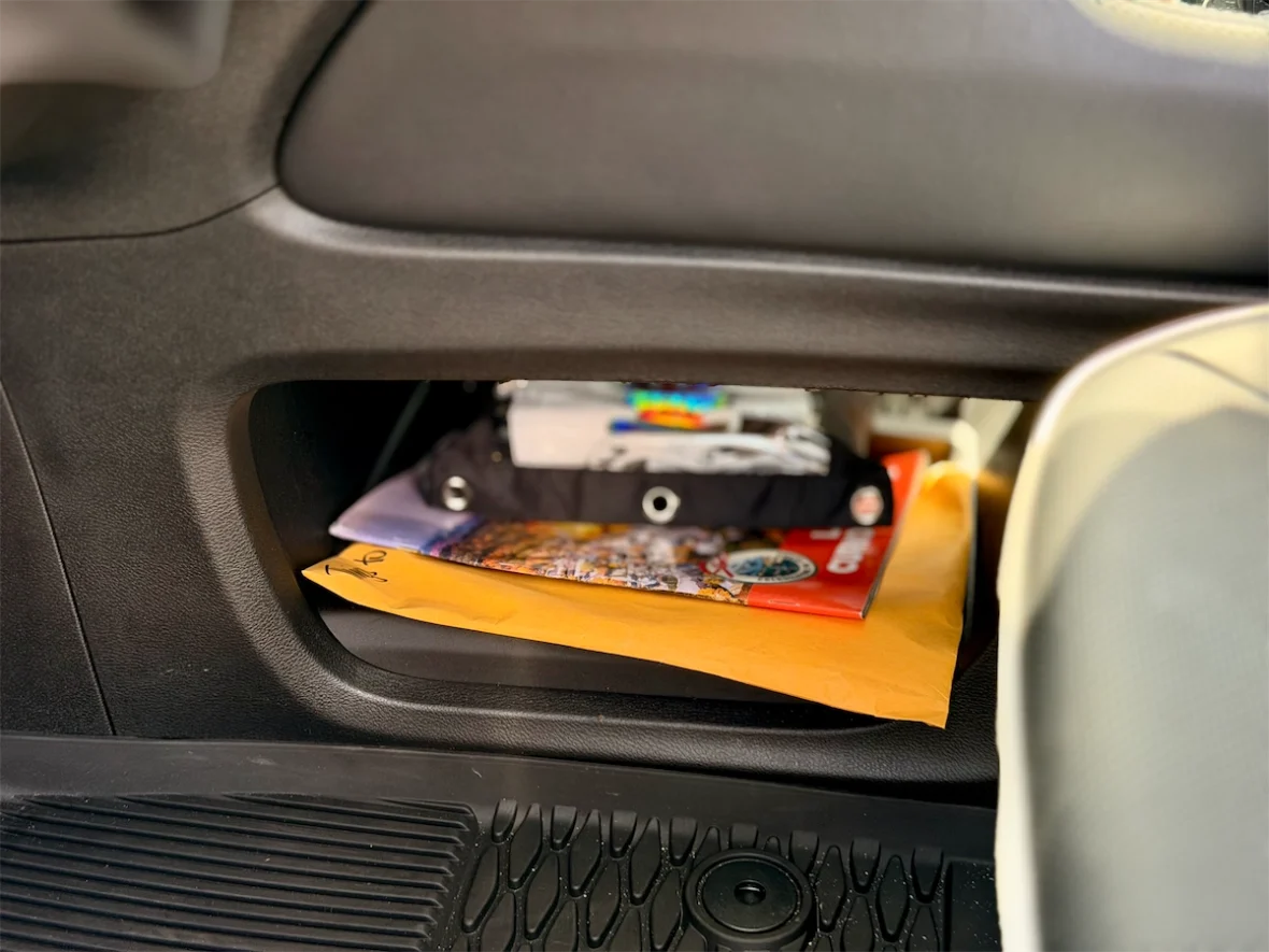 Open glovebox with owner's manual in a 2027 Chrysler Pacifica
