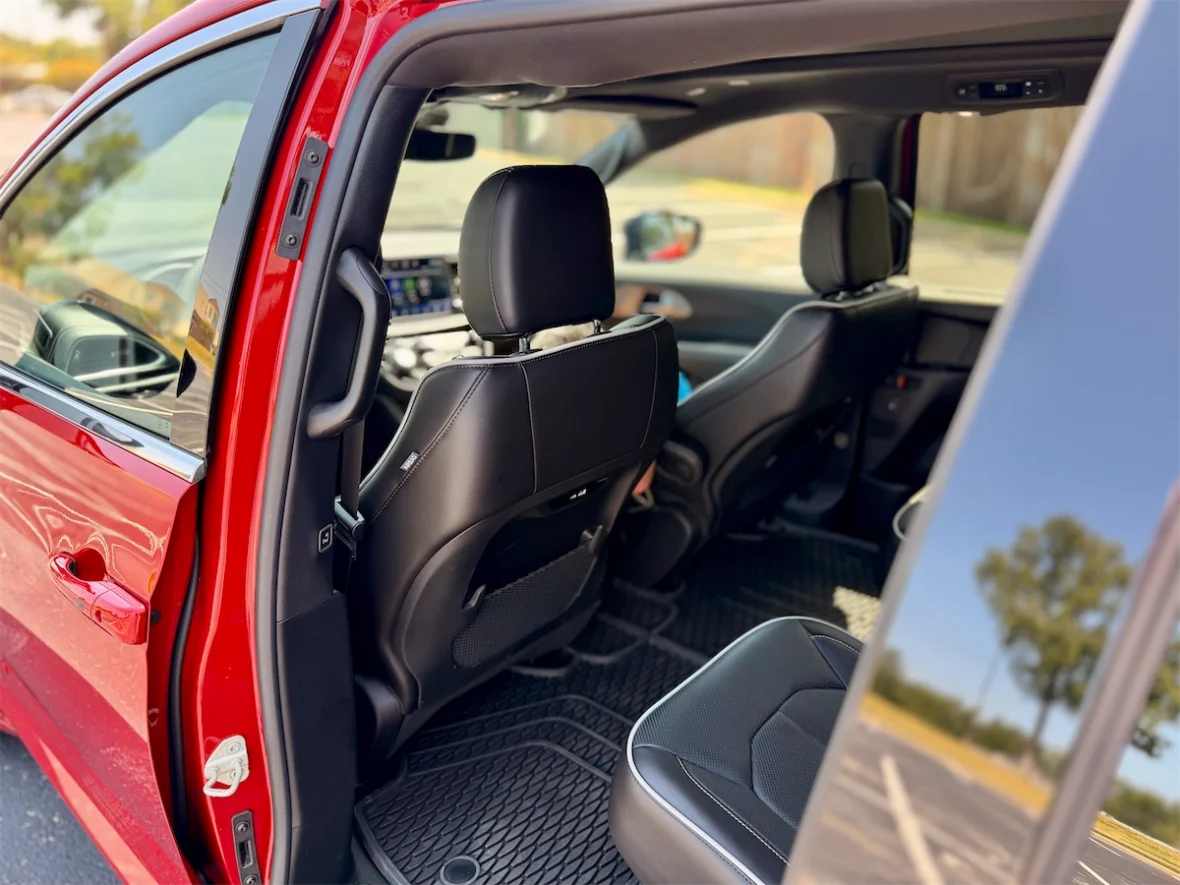Second-row seat viewed through the open sliding door of a 2027 Chrysler Pacifica