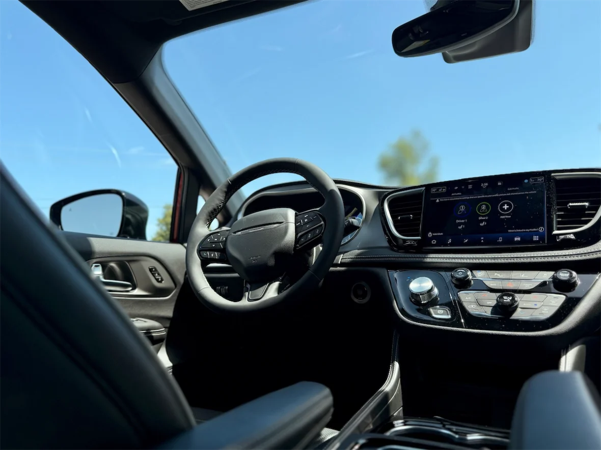 Front interior and dashboard from the passenger side of a 2027 Chrysler Pacifica
