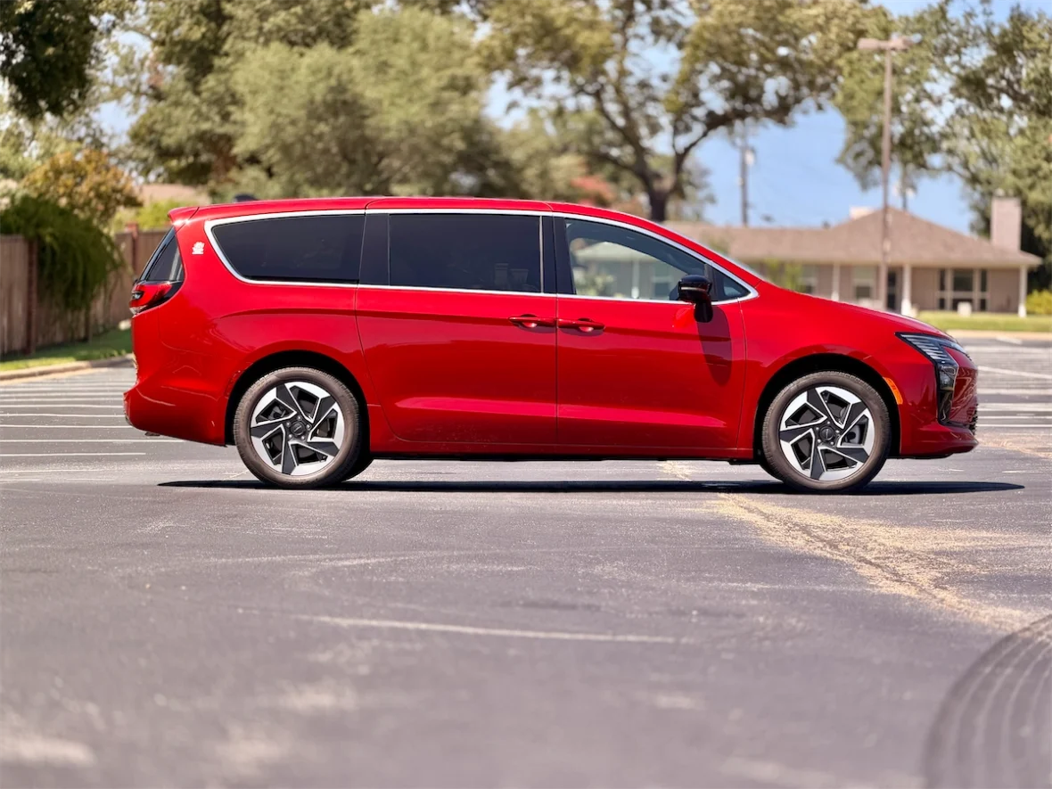 Profile of a red 2027 Chrysler Pacifica on a residential street