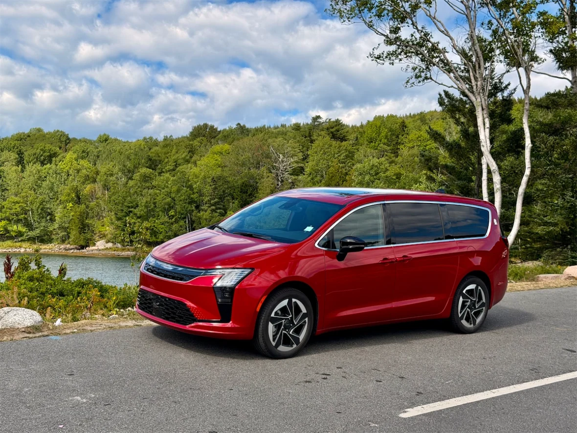 Red 2027 Chrysler Pacifica parked by a lake and forest in Acadia National Park