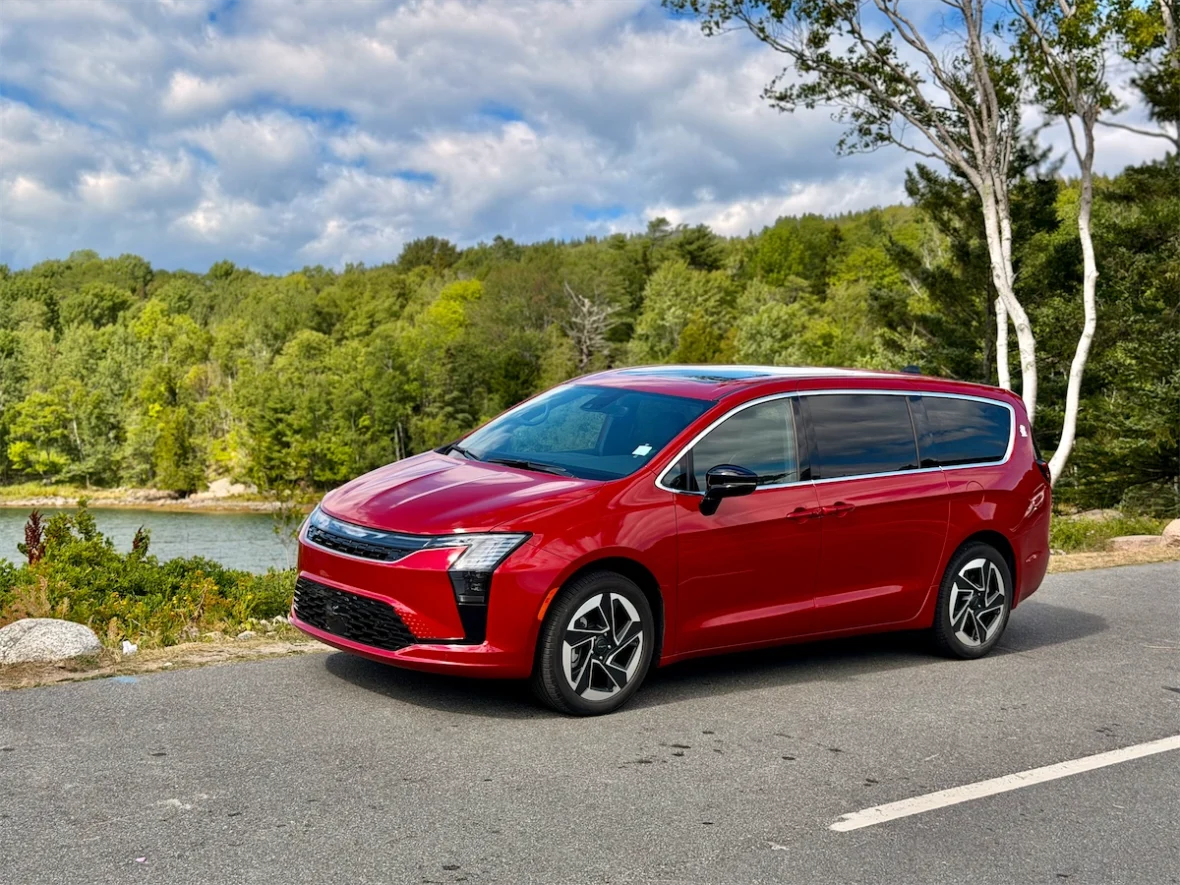 Red 2027 Chrysler Pacifica parked by a lake and birch trees in Acadia National Park