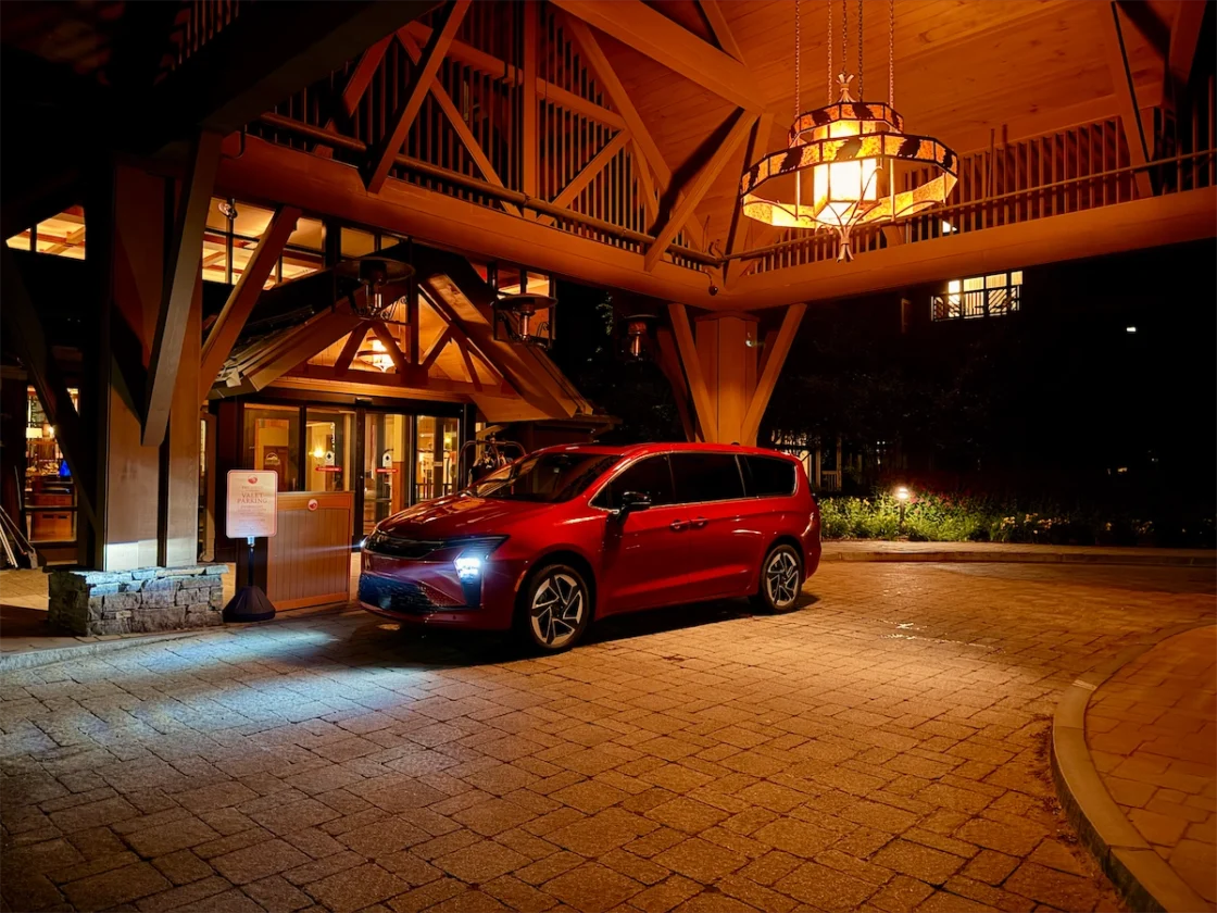 Red 2027 Chrysler Pacifica parked at night beneath a Vermont lodge portico in Stowe