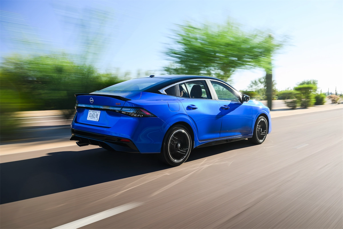 Blue sport sedan driving on a desert highway