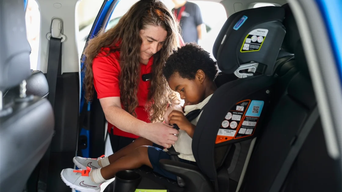 Child passenger safety technician demonstrates a car seat installation as part of the Hyundai car seat program
