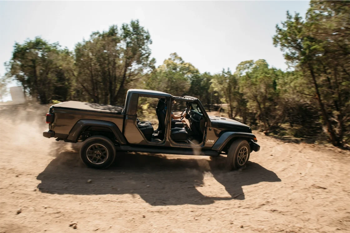 Cory Fourniquet driving a doors-off Jeep Gladiator through the dirt at the TAWA Truck Rodeo