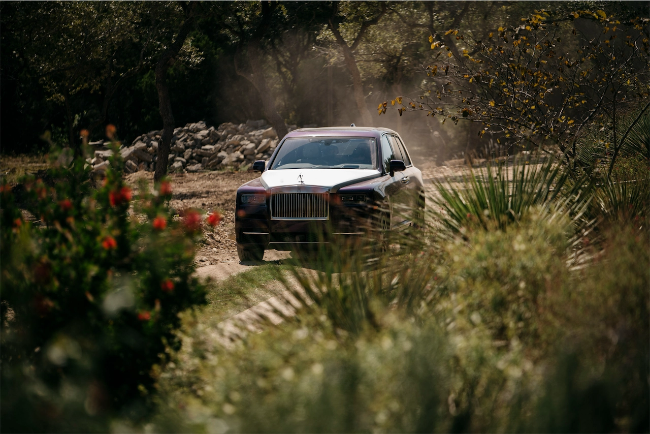 Rolls-Royce Cullinan driving through off-road brush