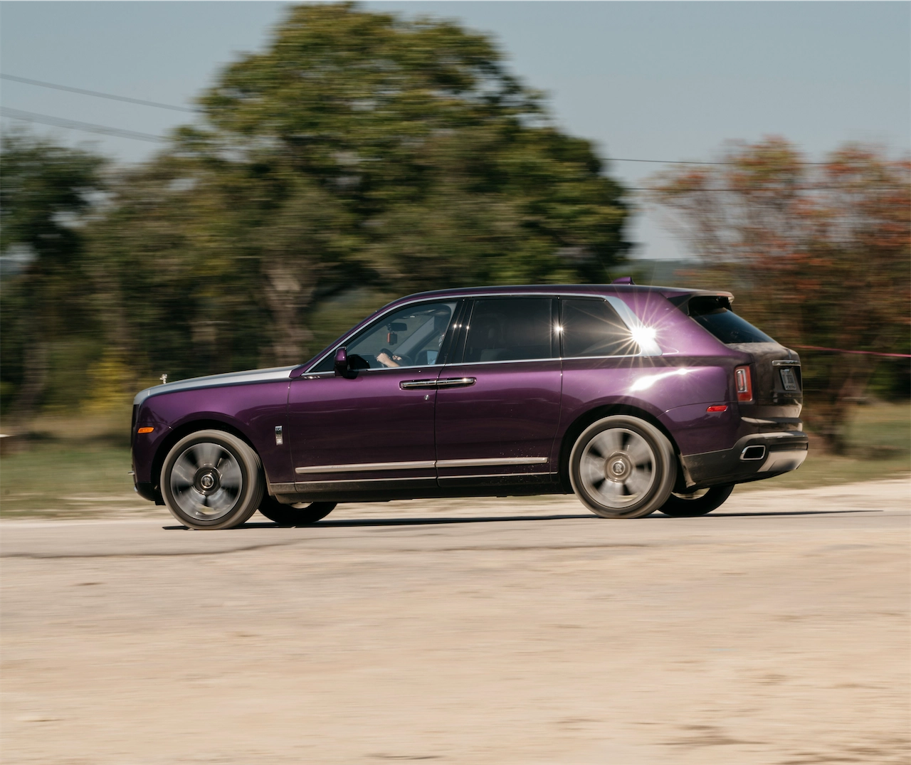 Purple 2020 Rolls-Royce Cullinan side profile on the road