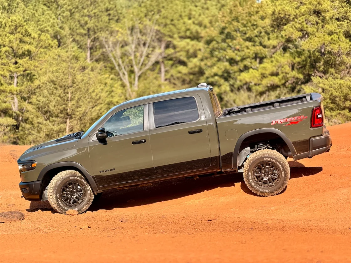 Tank green pickup truck flexing its suspension on an East Texas trail