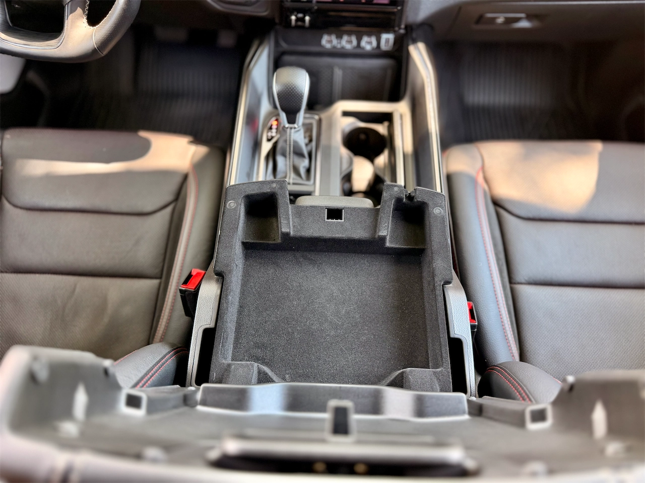 Two-tier center console storage with household outlet