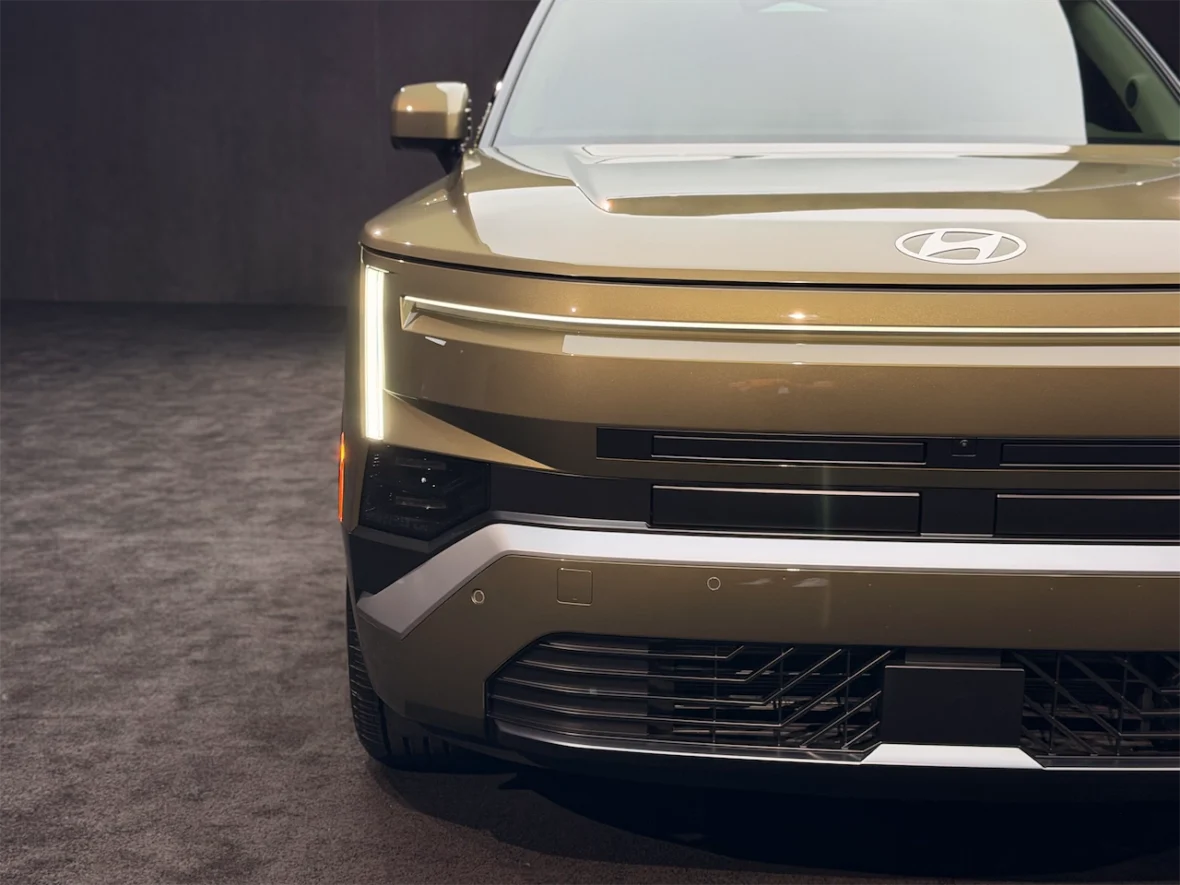 Close-up view of a modern, sleek SUV with a glossy brown finish, featuring distinctive LED headlights and a stylish front grille.