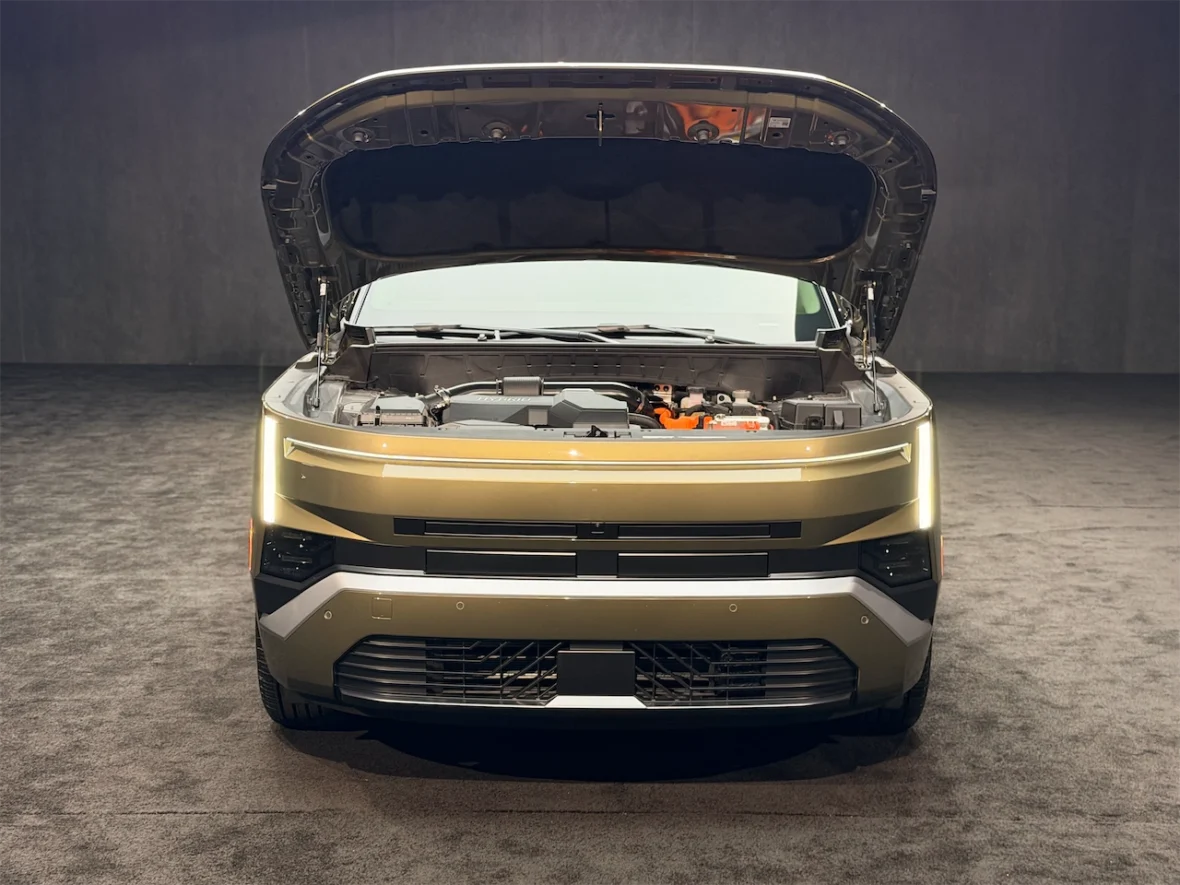 Front view of an electric vehicle with its hood open, showcasing the engine compartment.