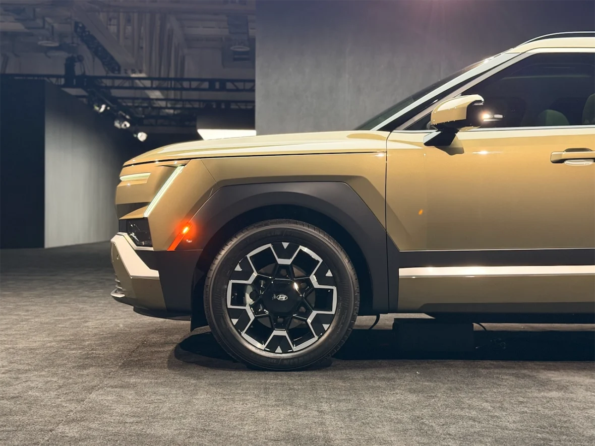 Side view of a modern SUV showcasing its distinctive design, including geometric wheel rims and a sleek body with a metallic finish.