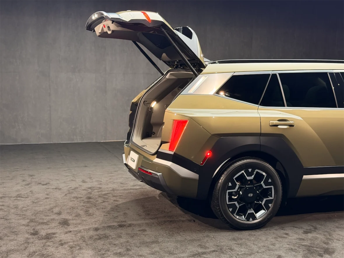 A rear view of a modern SUV with the trunk open, showcasing its spacious interior and sleek design.