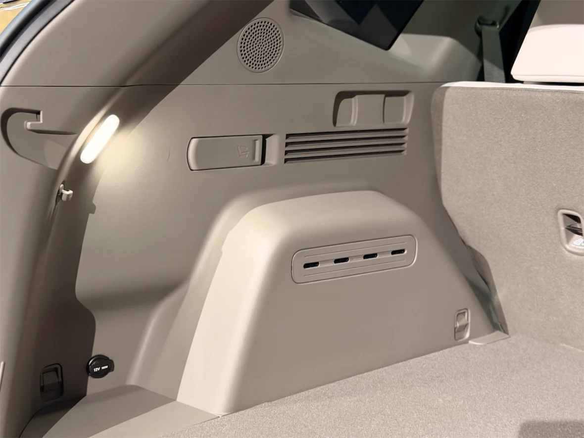 Interior view of a vehicle's rear compartment, featuring a light, various control elements, and a textured wall.