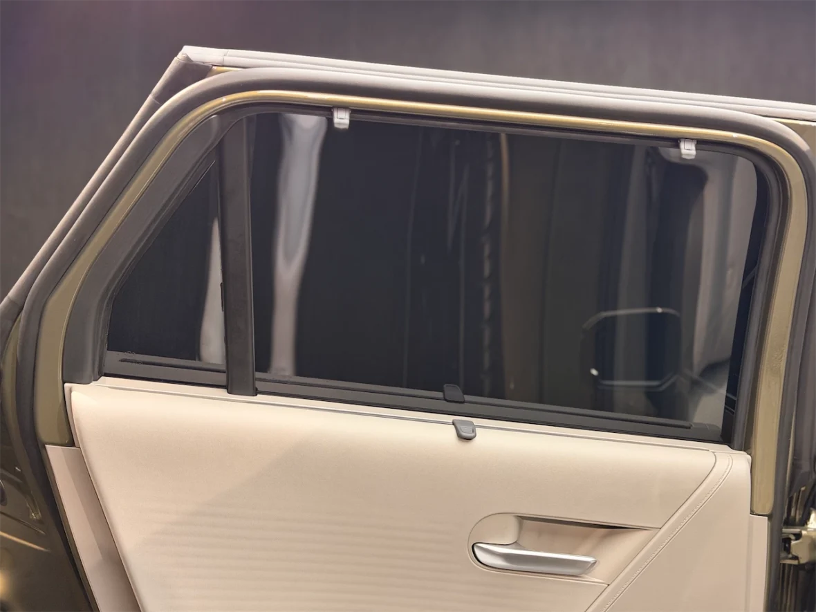 Close-up of an open car door showing the interior door panel and a partially opened window.