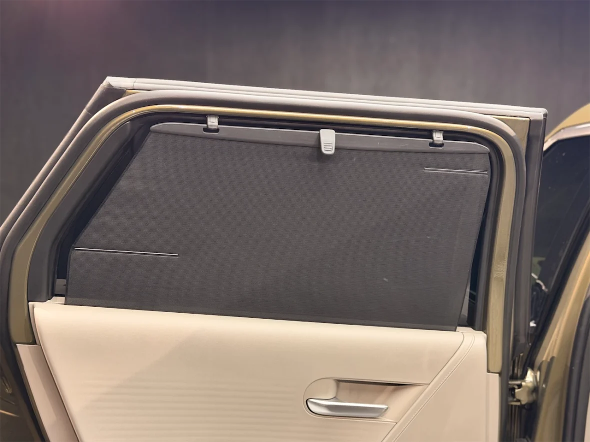 Close-up view of a car door featuring a retractable sunshade or window cover.