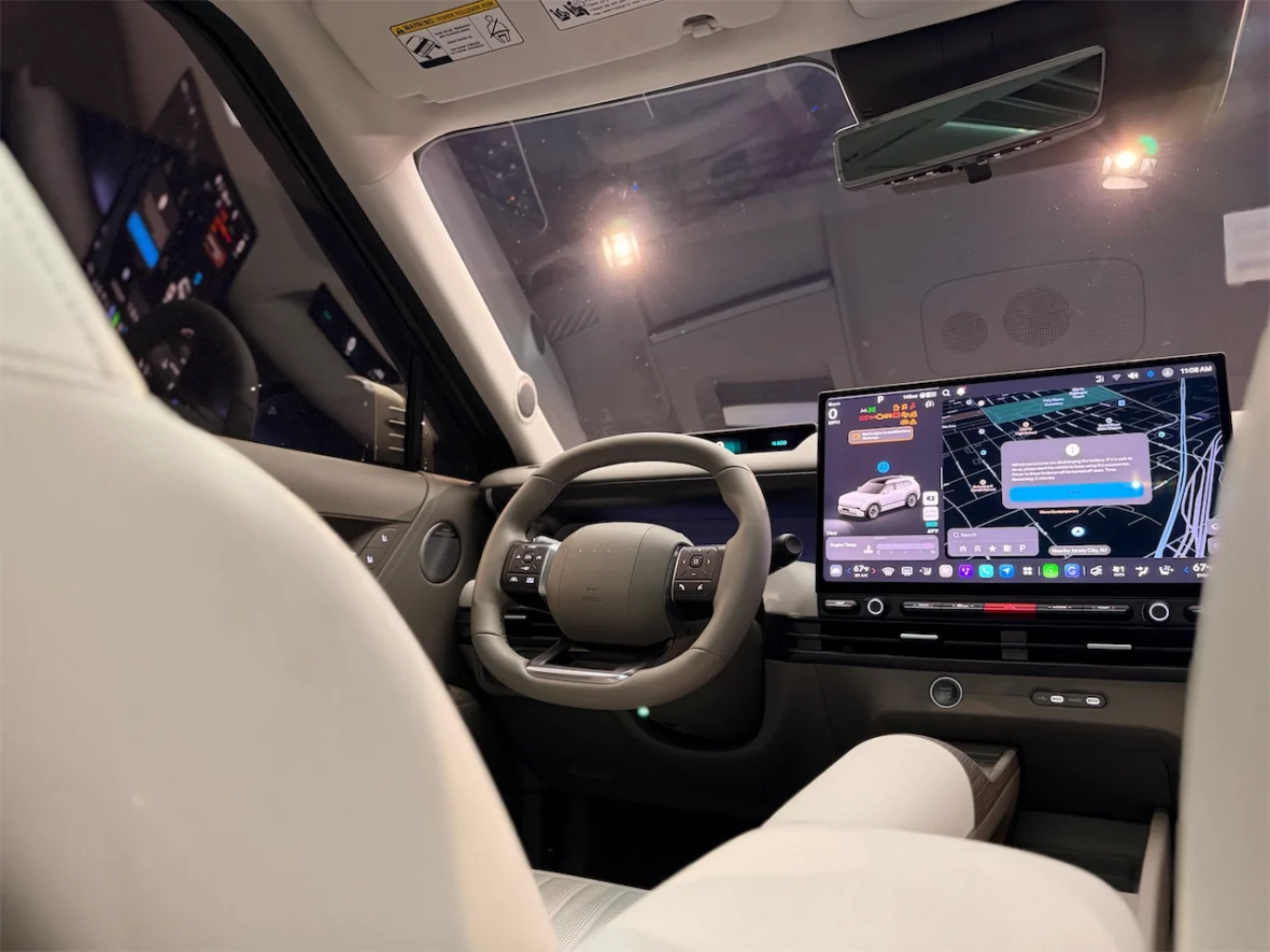 Interior view of a modern car showcasing a futuristic dashboard with a large touchscreen display and a steering wheel.