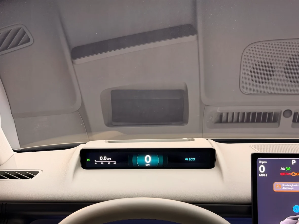 Interior dashboard view of a vehicle showing digital displays for speed and fuel economy.