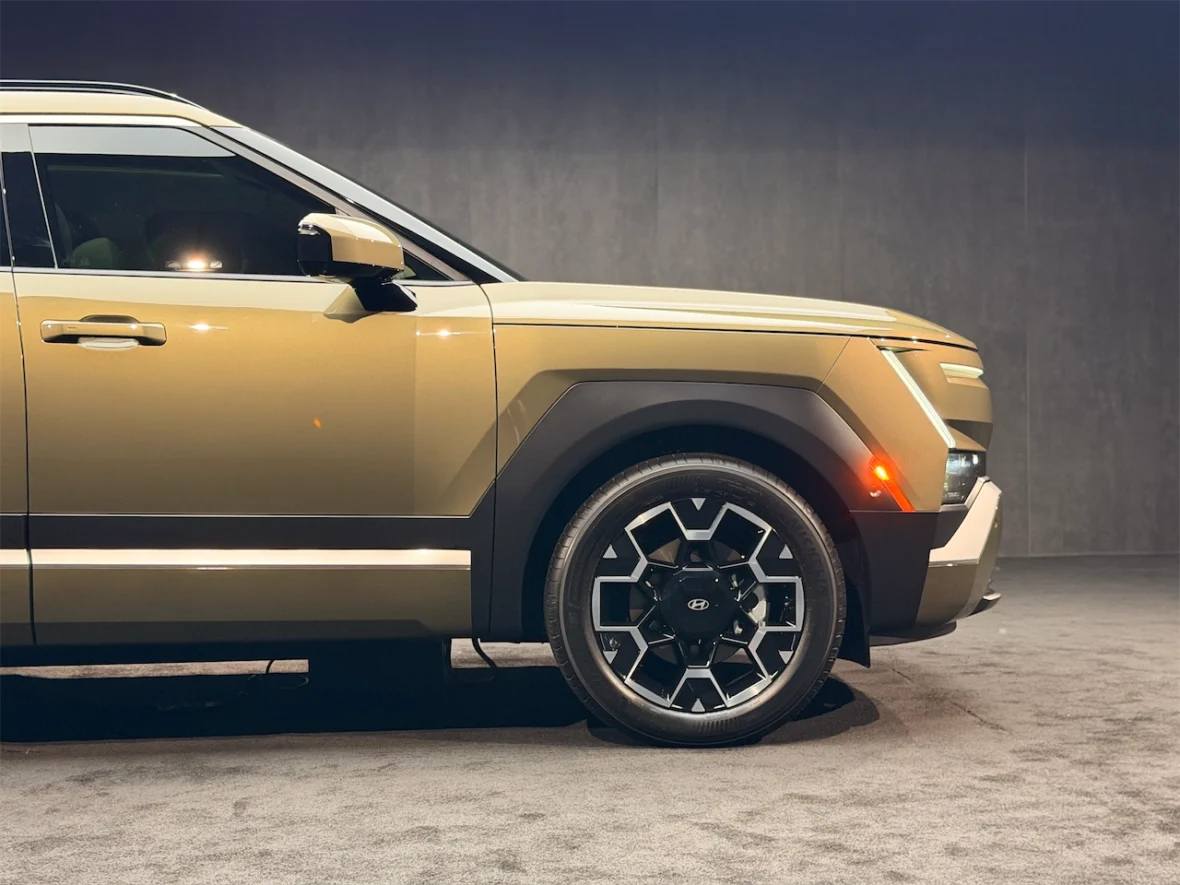Side view of a modern SUV showcasing its sleek design, two-tone color scheme, and distinctive wheel with a geometric pattern.