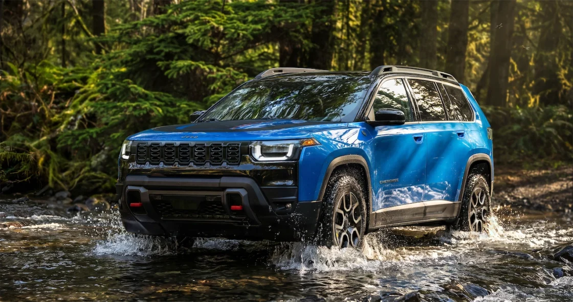 2027 Jeep Cherokee Trailhawk crossing a forest stream