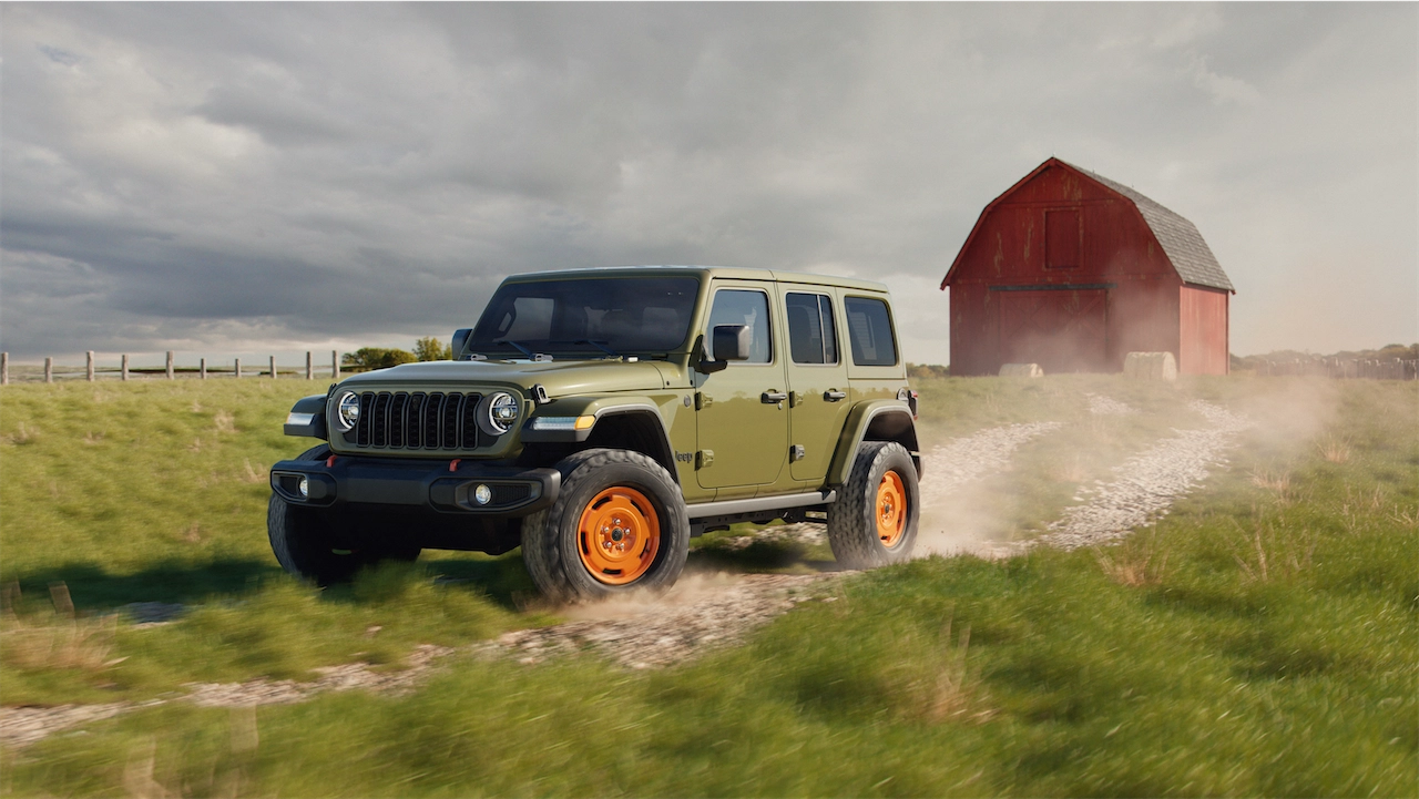Green four-door SUV in the '41 color kicking up dust past a red barn