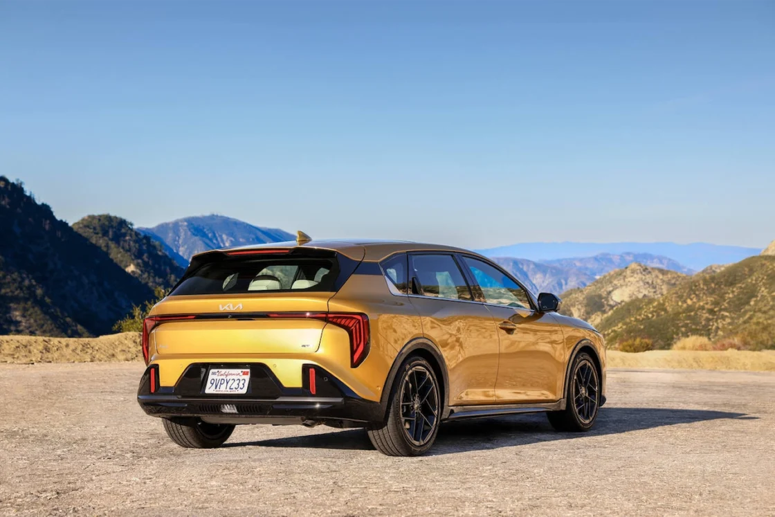 Gold 2027 Kia K4 hatchback parked at a mountain overlook