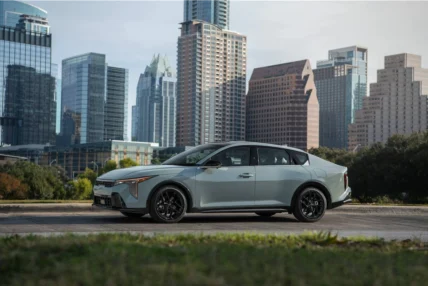 2027 Kia K4 sedan in front of a city skyline