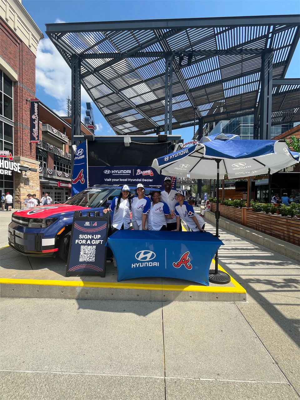 Hyundai and Atlanta Braves representatives beside a Braves-themed Santa Fe