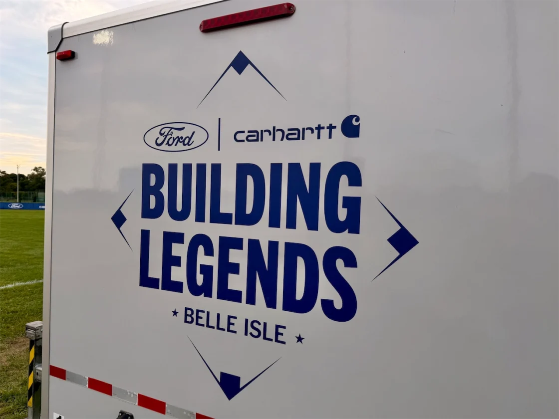 A Ford and Carhartt Building Legends Belle Isle trailer parked beside the baseball field.
