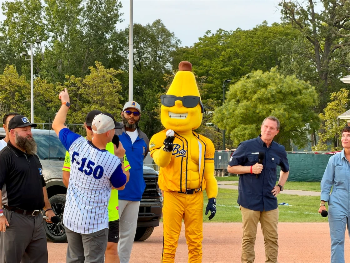 Speakers and a costumed mascot address the crowd at the Ford Community Field dedication on Belle Isle.