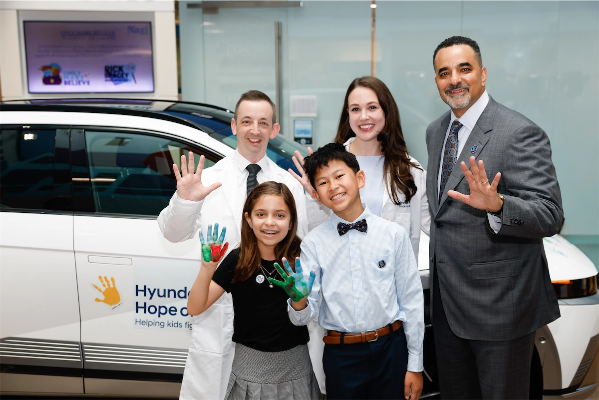 Children add painted handprints to a Hyundai Hope on Wheels vehicle during a handprint ceremony