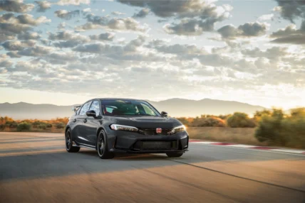 Dark gray 2027 Honda Civic Type R on a racetrack at sunset with mountains behind it