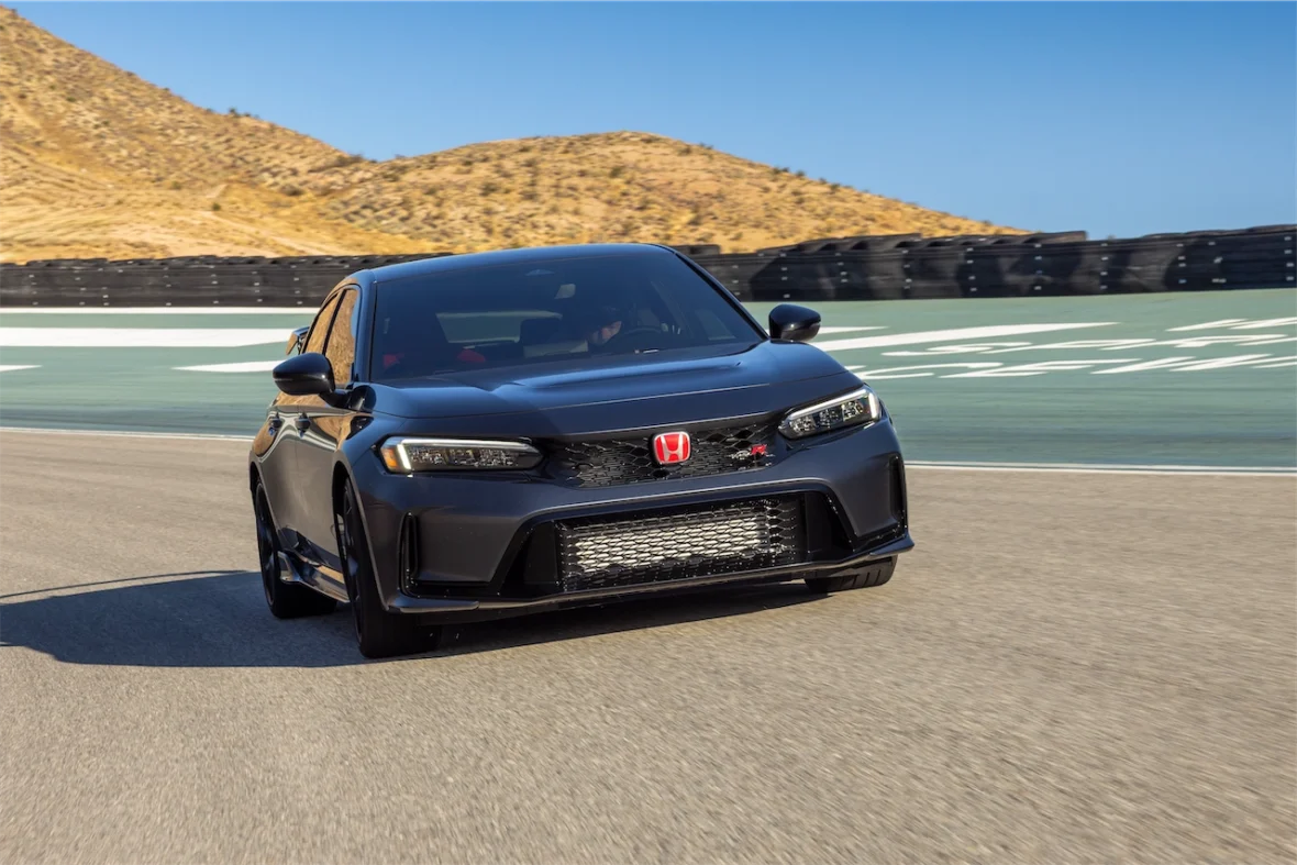 Front view of a dark gray Civic Type R on a track with desert hills in the background