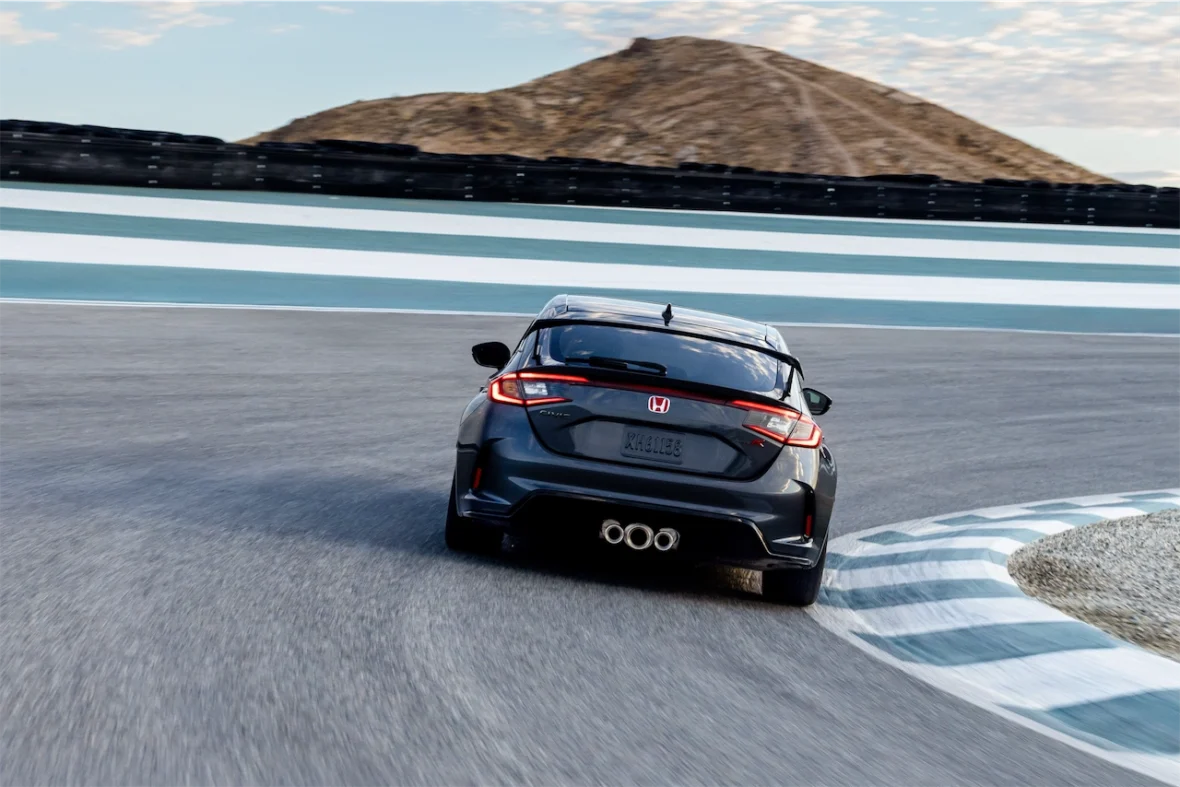 Rear view of a Civic Type R cornering on a racetrack, showing its triple exhaust tips