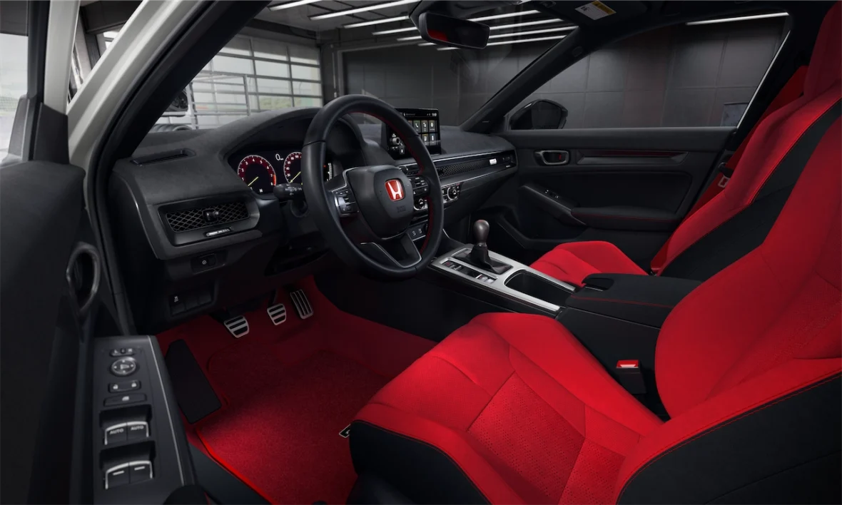 View through the driver's door of the Civic Type R interior with red sport seats and red carpet