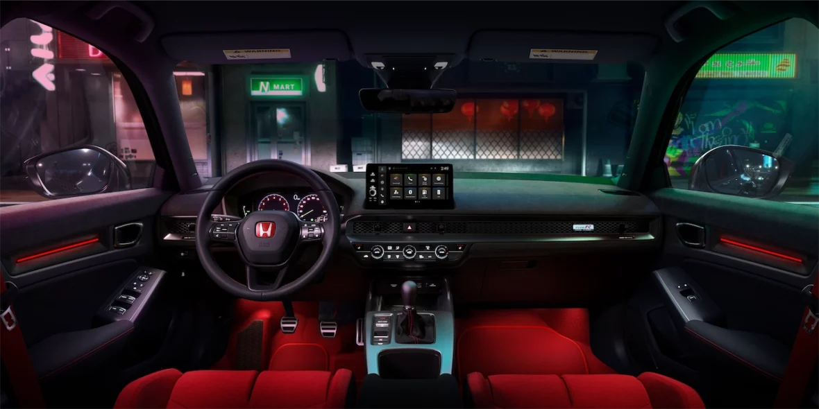 Civic Type R interior at night with the dashboard screens and red seats lit up