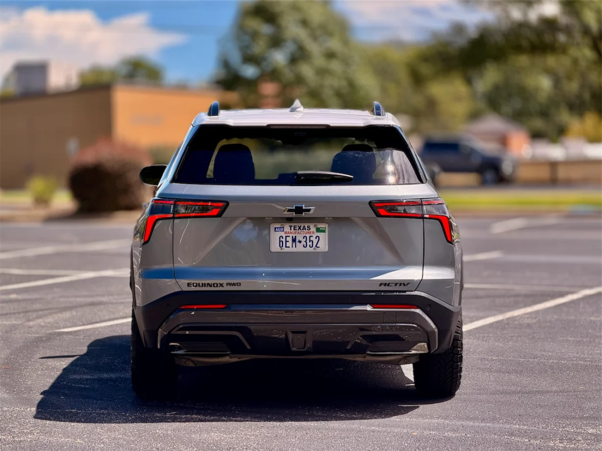 Rear view of a gray Chevrolet Equinox parked in a lot, showcasing its distinctive taillights and 'AWD' badge.