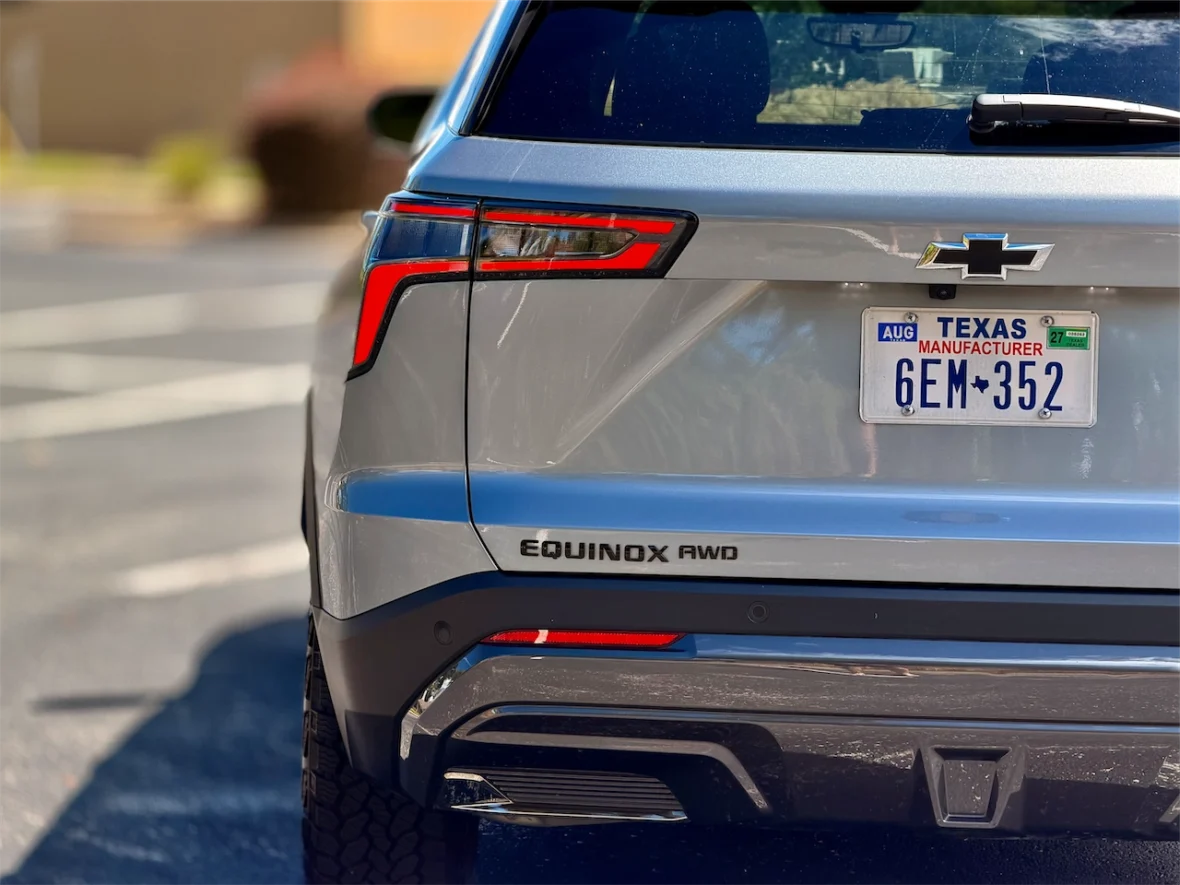 Rear view of a silver Chevrolet Equinox showcasing the model name 'EQUINOX AWD' and a Texas license plate.