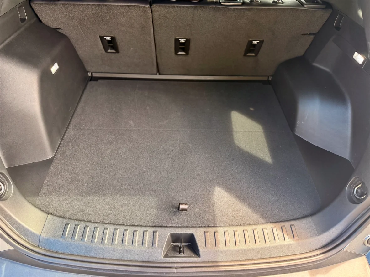 Empty trunk space of a car with a flat floor and rear seats folded down.