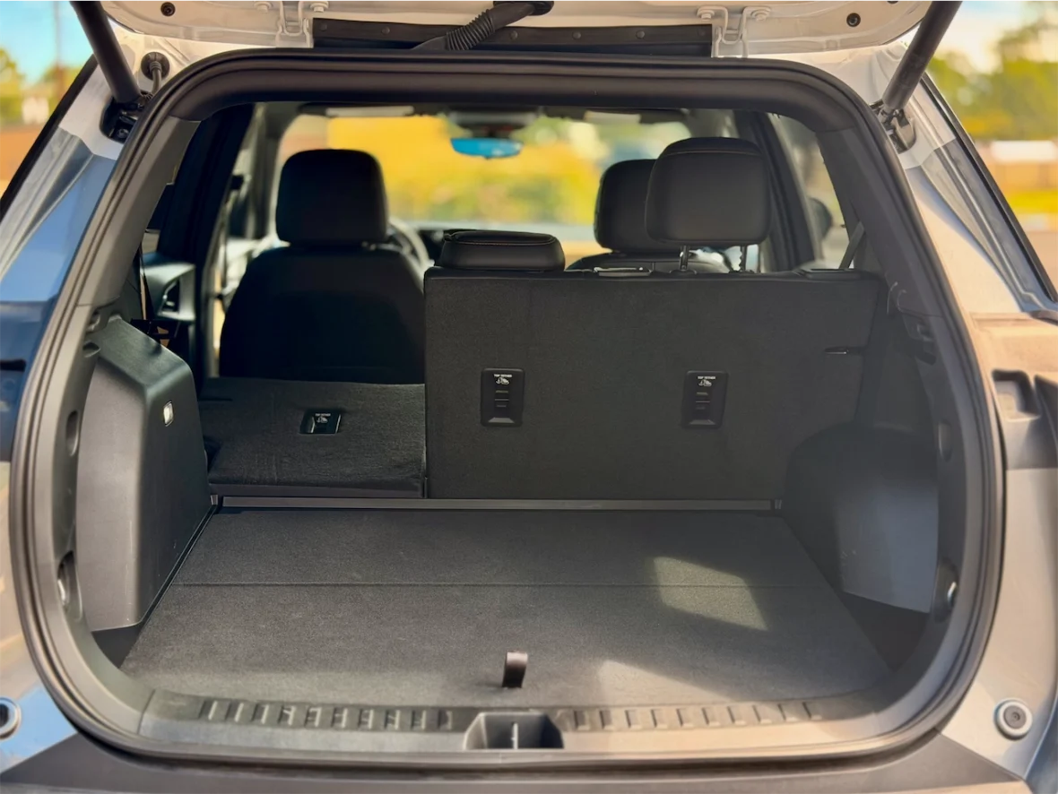 Interior view of an SUV trunk with the back seats folded down, showing a spacious cargo area.