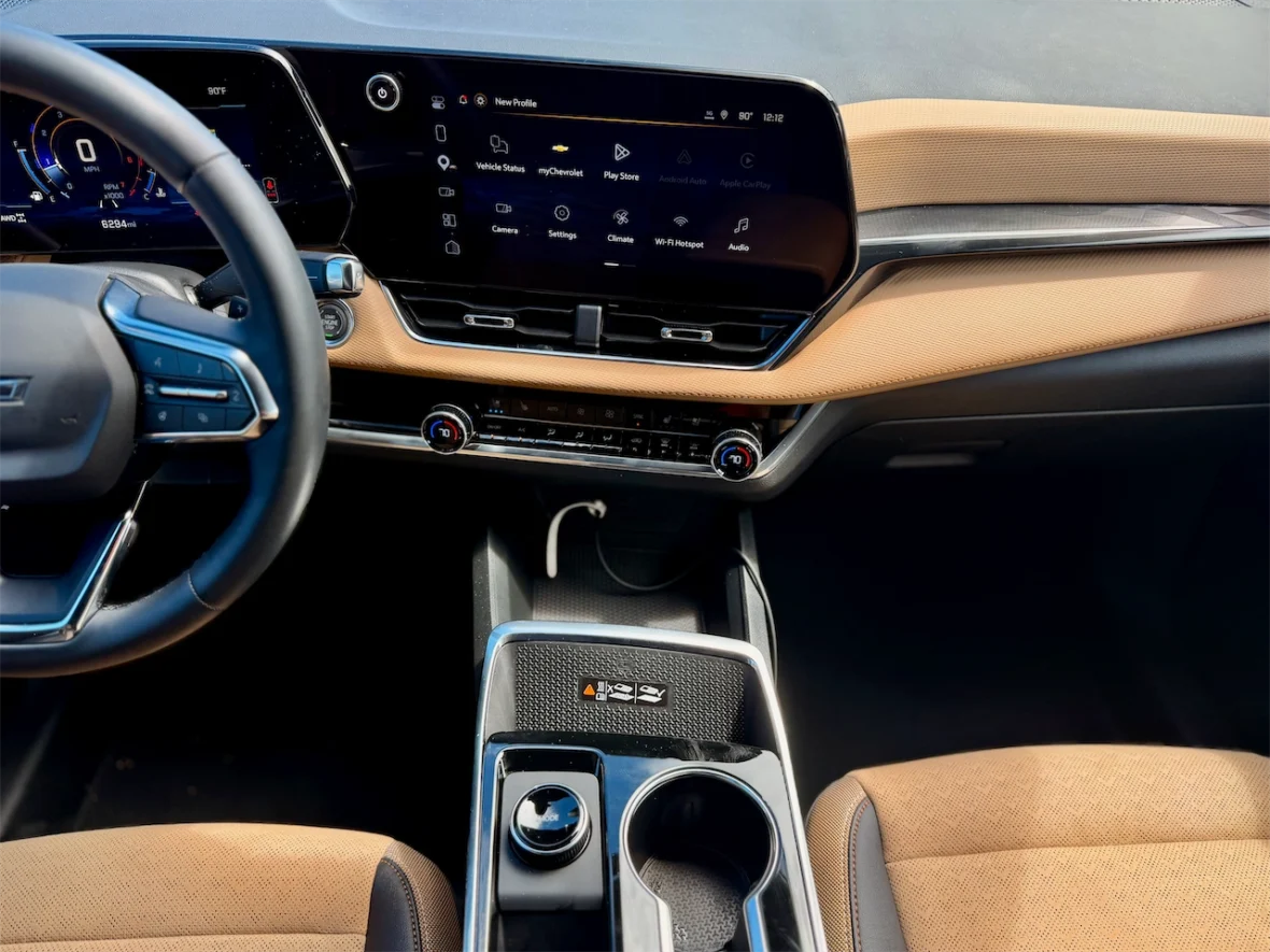 Interior view of a modern car dashboard featuring a digital speedometer, a touch screen display with various applications, and a stylish center console with controls and cup holders.