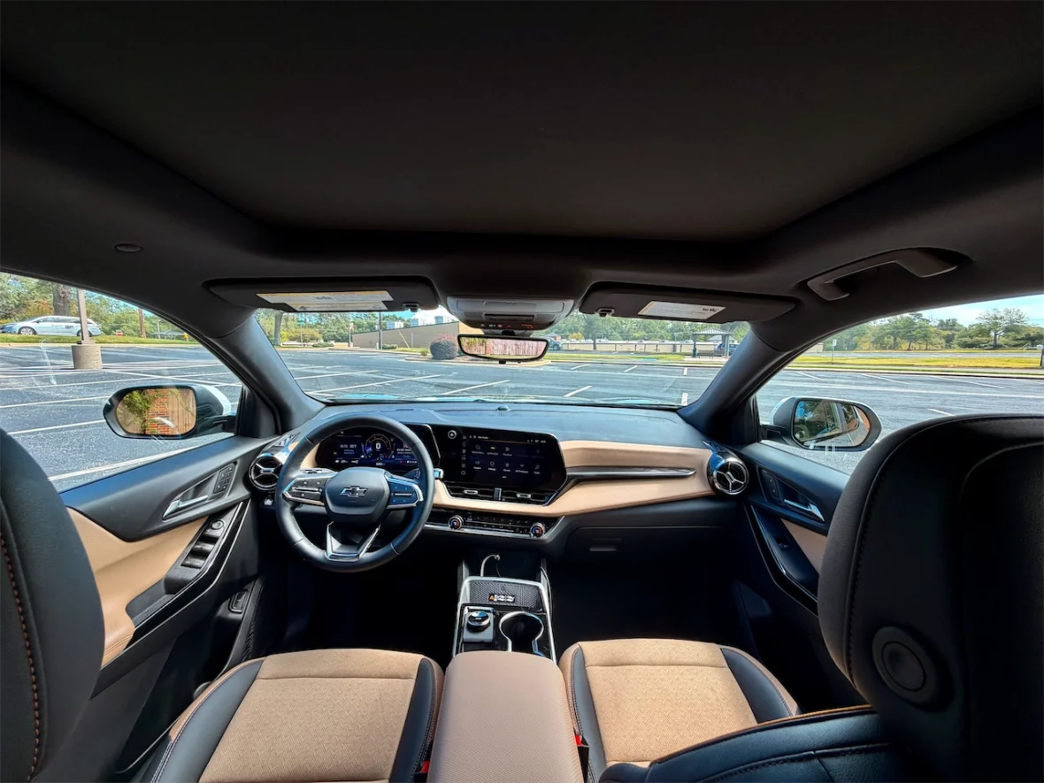Interior view of a modern car, showing the dashboard, steering wheel, and passenger seats with a focus on the driver's side.