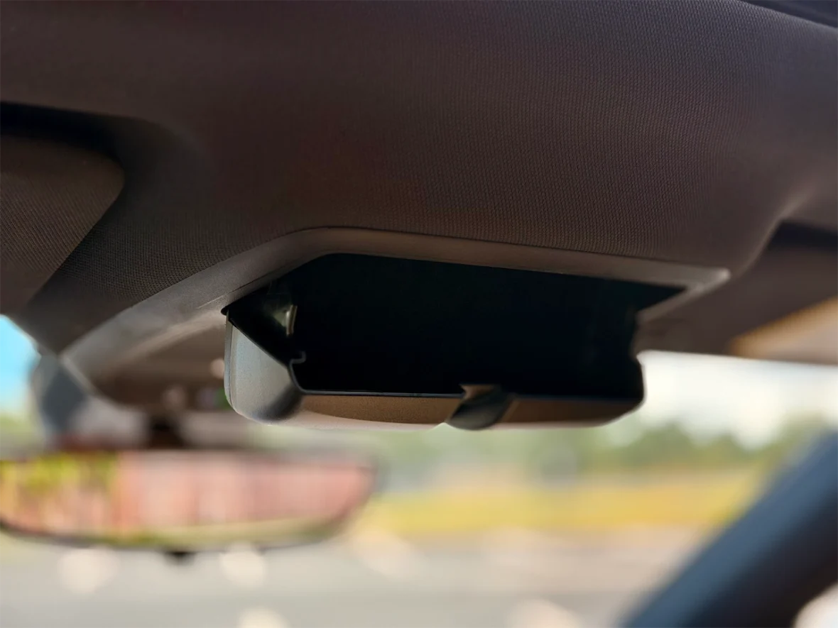 Close-up of a car's overhead sunglasses holder mounted on the interior ceiling.