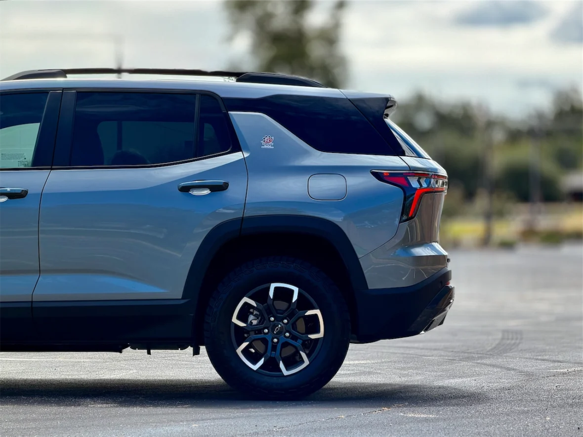 Side view of a modern silver SUV parked on a paved surface, showcasing its sleek design and alloy wheels.