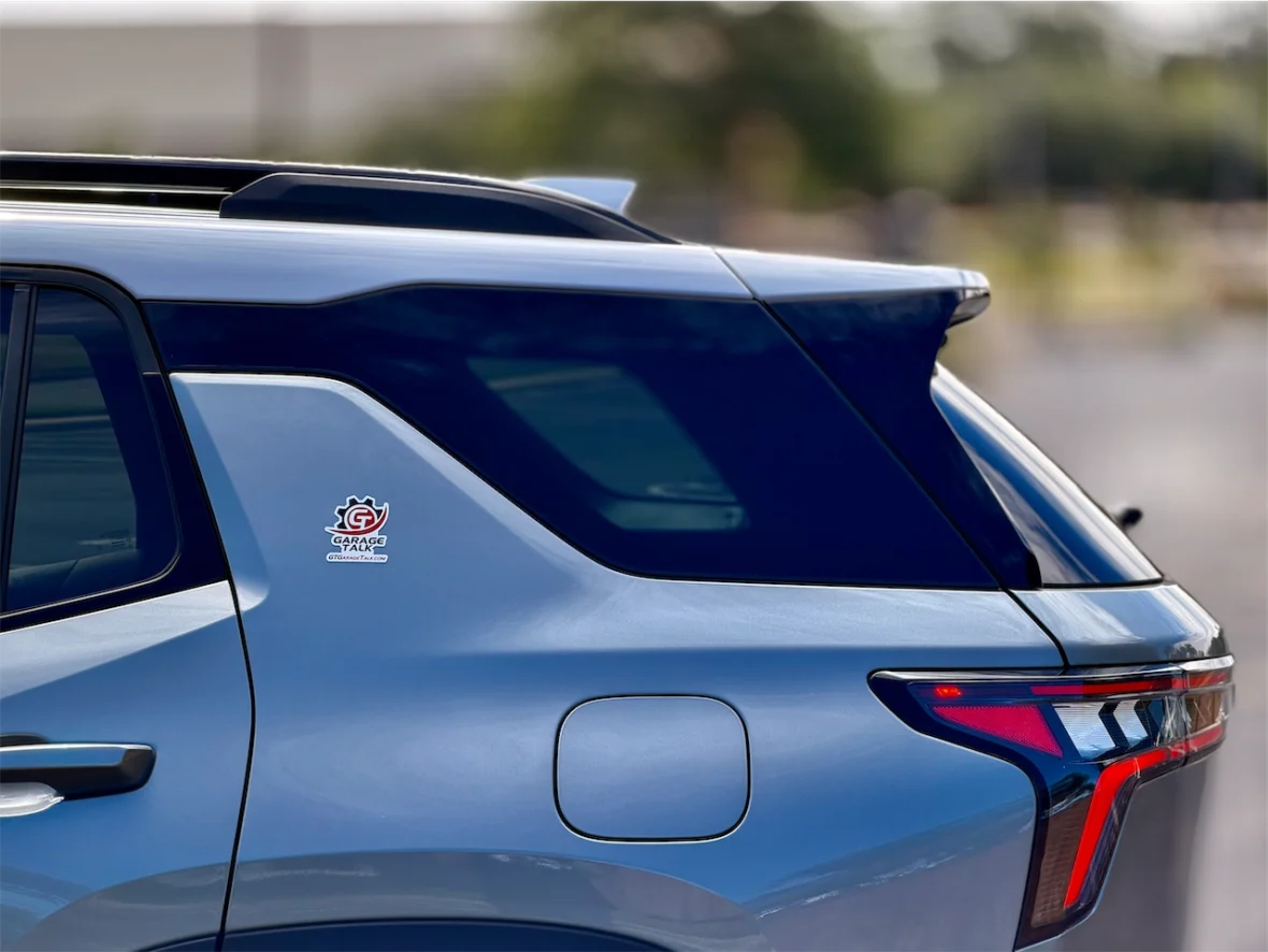 A close-up of the rear side of a blue vehicle showcasing the 'Garage' sticker and sleek design details.